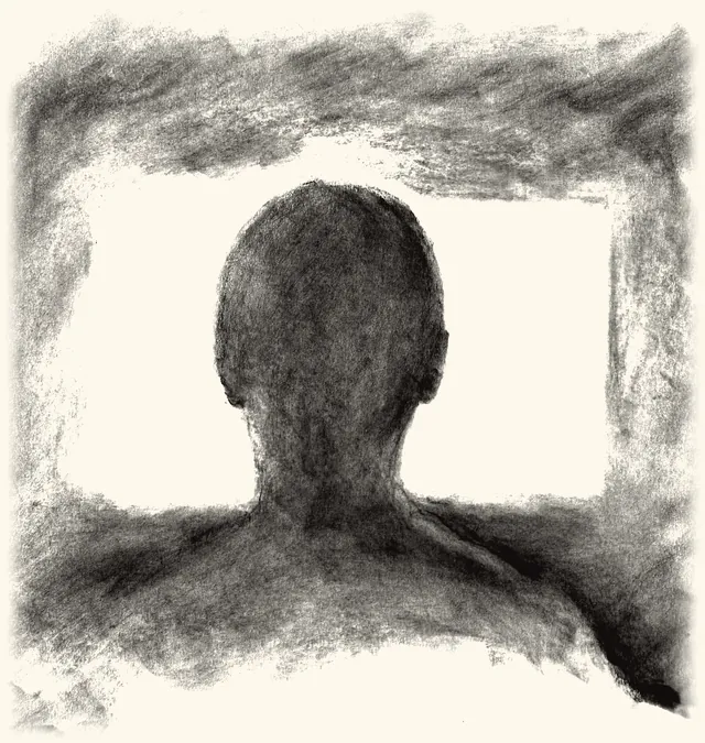 A man seen from behind against a glowing screen.