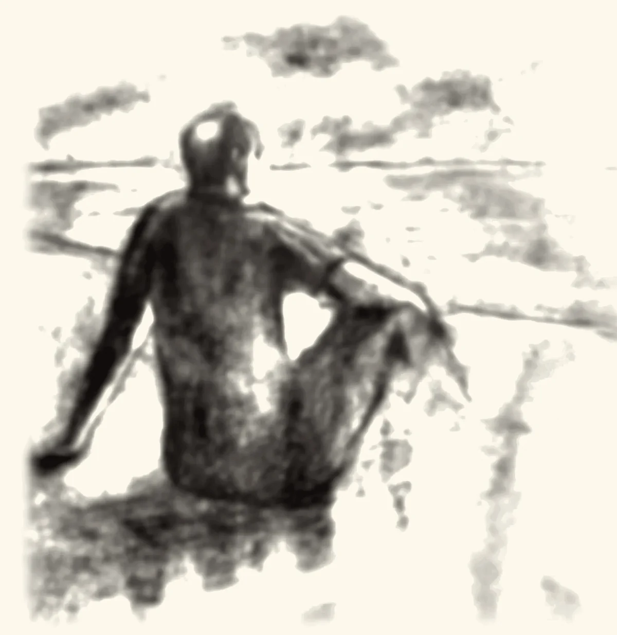 A man sitting alone, looking out over open ground.